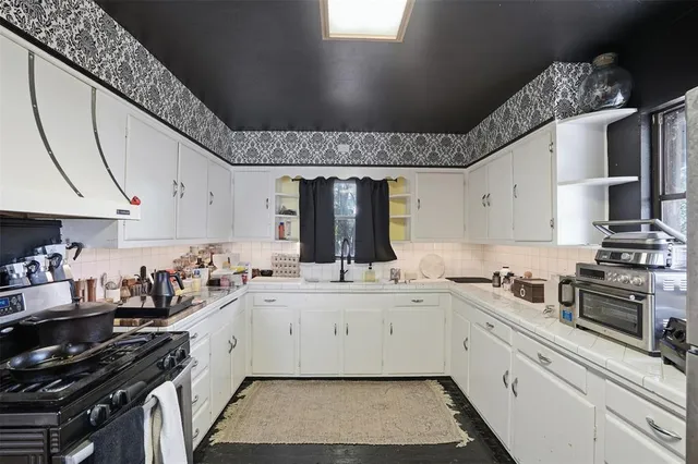 a kitchen with stainless steel appliances a sink a stove and cabinets