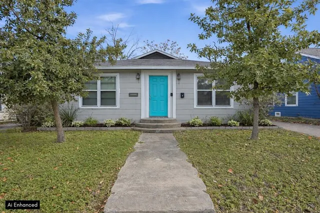 a front view of a house with a garden and yard