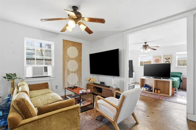 a bedroom with furniture a flat screen tv and a window