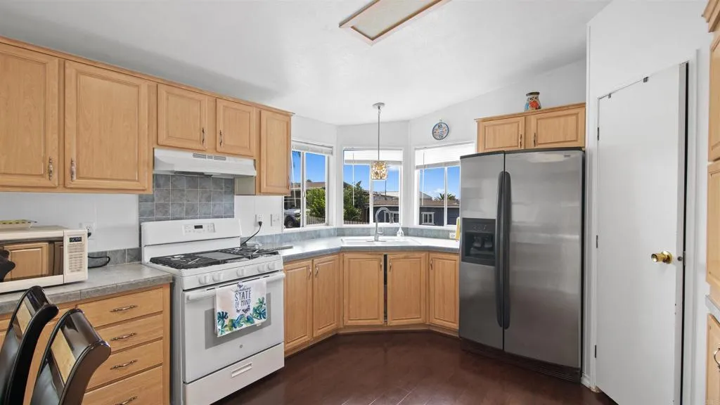 1455 Alturas Street, Unit 55 Fallbrook, CA 92028 - Photo 3 of 31 a kitchen with stainless steel appliances granite countertop a refrigerator sink and white cabinets