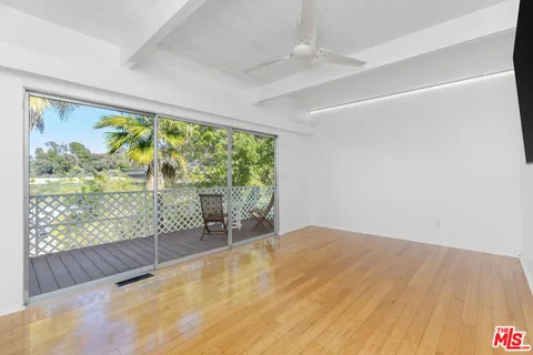 a view of empty room with wooden floor and outdoor space