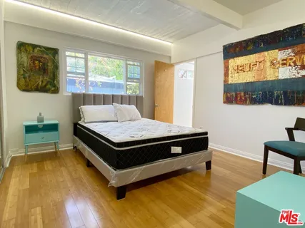 a bedroom with a bed and a flat screen tv