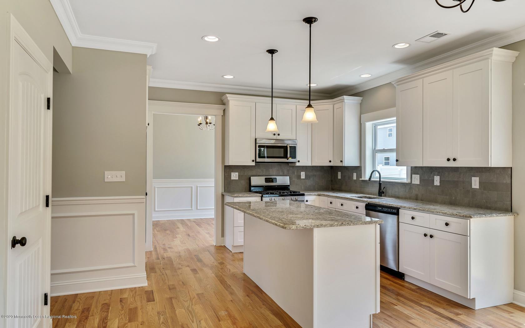 615 Ivanhoe Road Brick, NJ 08723 - Photo 12 of 28 a kitchen with a refrigerator a sink and wooden floor