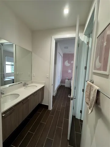 a bathroom with a double vanity sink and a mirror