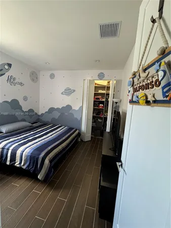 a bedroom with bed and wooden floor