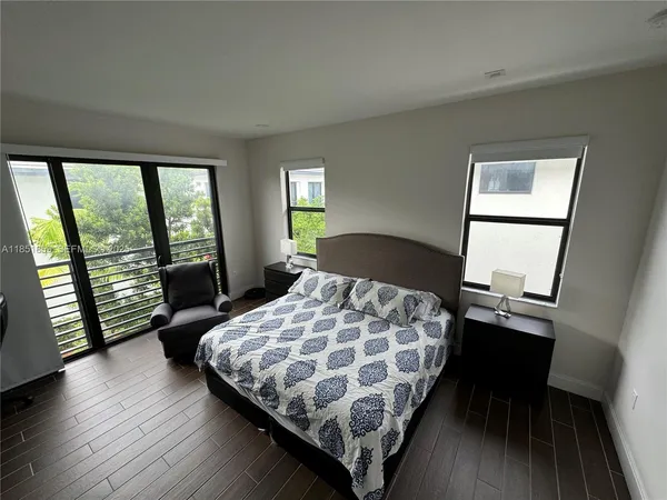 a bedroom with a bed window and wooden floor