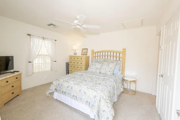 a bedroom with a bed and a flat tv screen on dresser