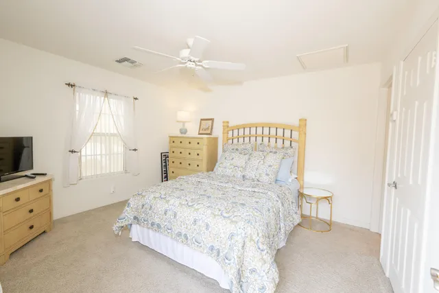 a bedroom with a bed and a flat tv screen on dresser