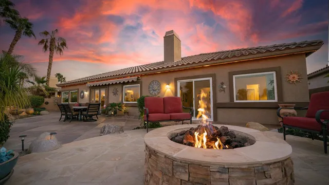 a view of a patio with table and chairs with plants and wooden fence