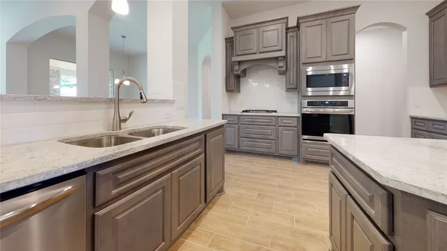 a kitchen with stainless steel appliances granite countertop a sink and cabinets