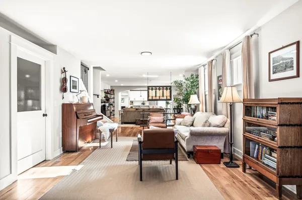 a living room with furniture a rug and a bookshelf