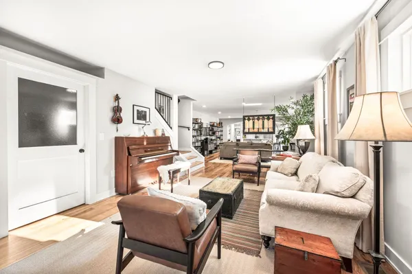 a living room with furniture large window and wooden floor