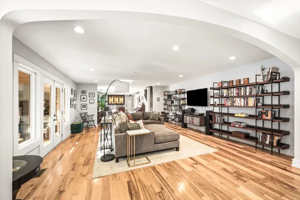 a kitchen with stainless steel appliances a stove a sink dishwasher and a dining table with wooden floor