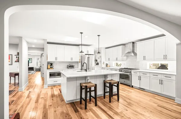 a large white kitchen with a stove and refrigerator