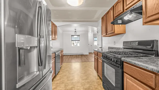 a kitchen with stainless steel appliances granite countertop a stove and a refrigerator