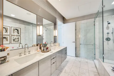 a bathroom with a double vanity sink mirror and shower