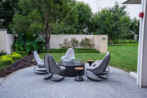 a view of a chairs and backyard with table and chairs with plants and garden
