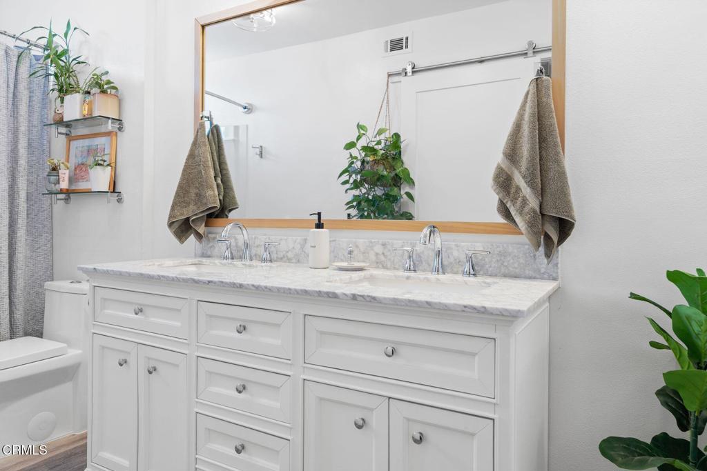551 South E Street Oxnard, CA 93030 - Photo 12 of 16 a bathroom with a granite countertop sink and a mirror