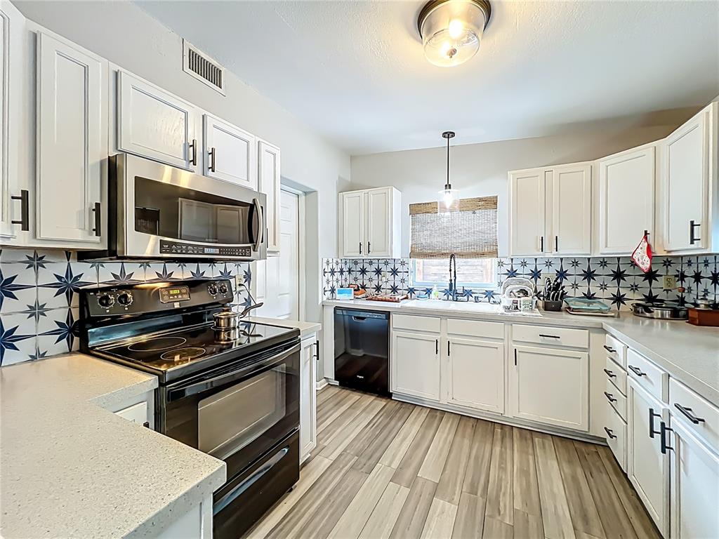 1700 Edmundshire Road Orlando, FL 32812 - Photo 14 of 43 a kitchen with granite countertop a stove sink and microwave