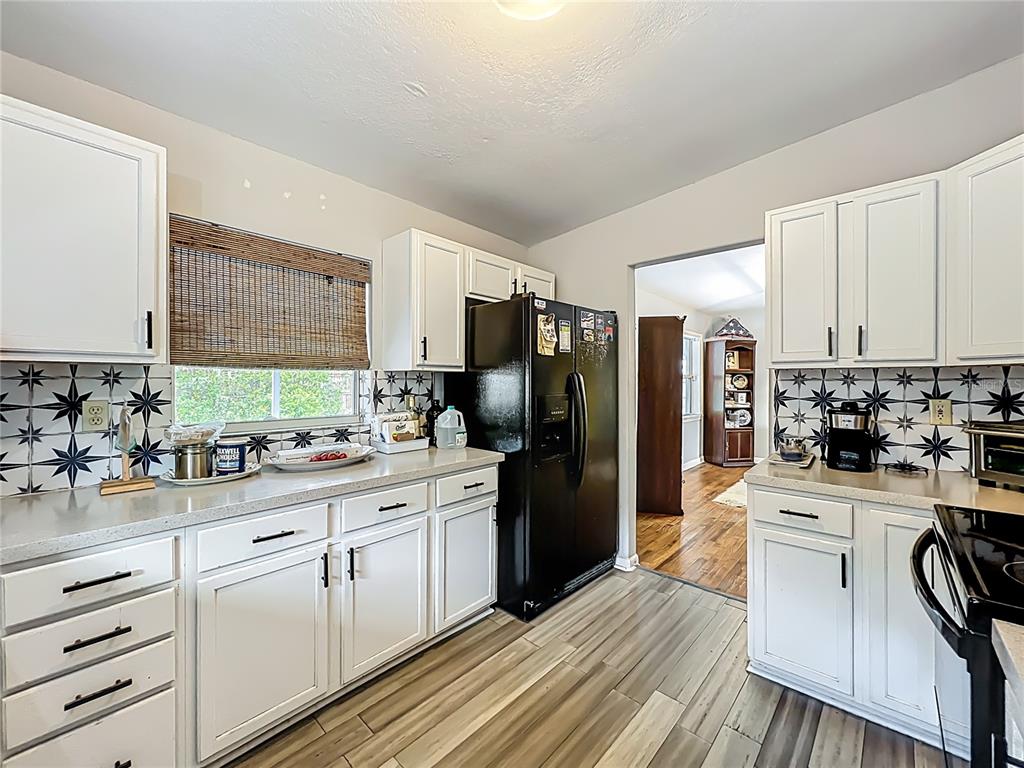 1700 Edmundshire Road Orlando, FL 32812 - Photo 17 of 43 a kitchen with white cabinets and stainless steel appliances