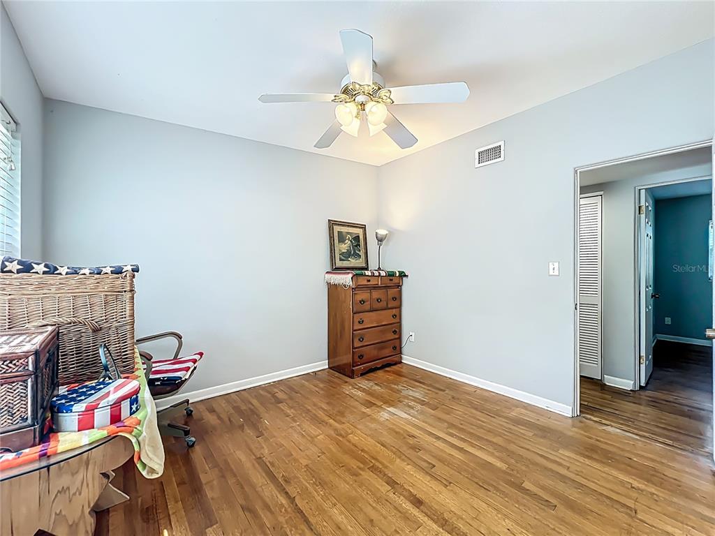 1700 Edmundshire Road Orlando, FL 32812 - Photo 19 of 43 a bedroom with a bed and wooden floor