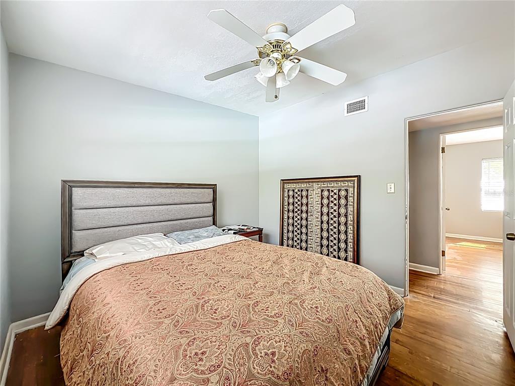 1700 Edmundshire Road Orlando, FL 32812 - Photo 21 of 43 a bedroom with a large bed and a chandelier