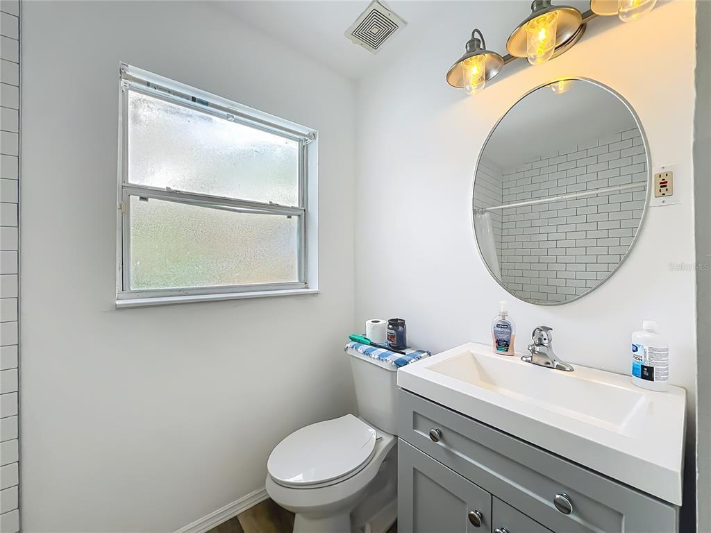 1700 Edmundshire Road Orlando, FL 32812 - Photo 23 of 43 a bathroom with a toilet a sink and mirror