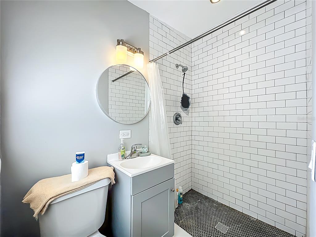 1700 Edmundshire Road Orlando, FL 32812 - Photo 27 of 43 a bathroom with a granite countertop toilet sink and mirror