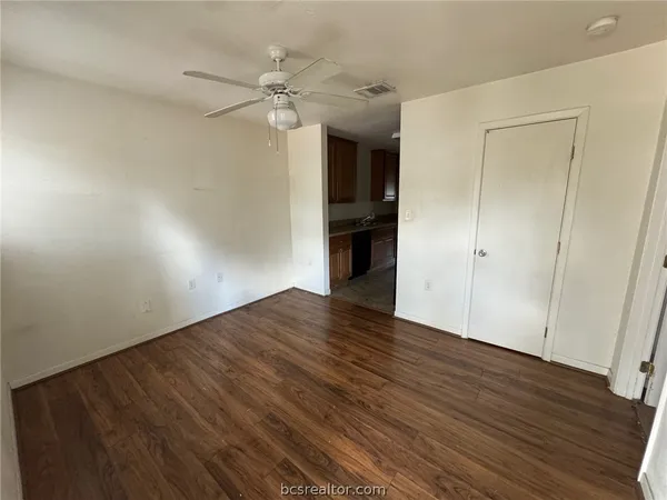 a view of an empty room with wooden floor