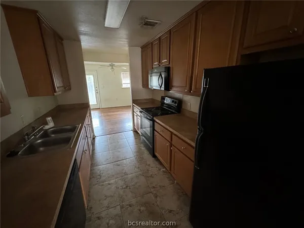a kitchen with a sink stove and cabinets