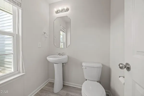 a bathroom with a toilet a sink and a window