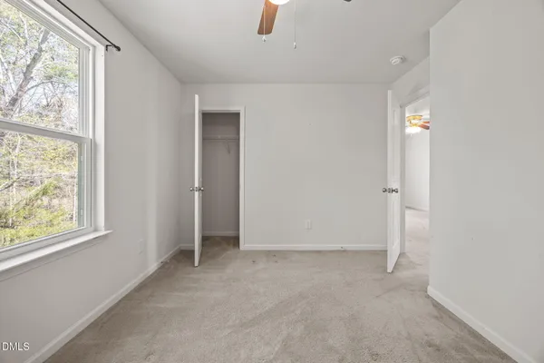 an empty room with windows and closet