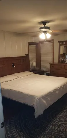 a bedroom with a large bed and a chandelier