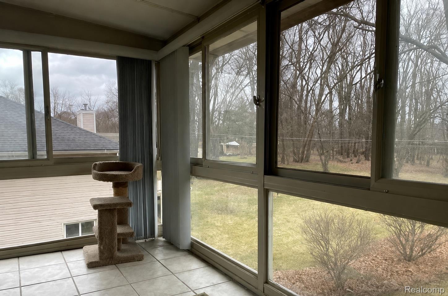 9552 Wayne Road Livonia, MI 48150 - Photo 17 of 31 Enclosed porch featuring large windows, tile flooring, and a wooded backdrop