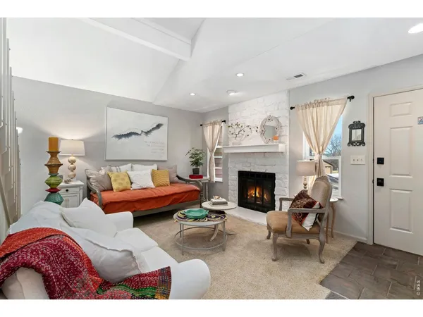 a living room with furniture a fireplace and a table