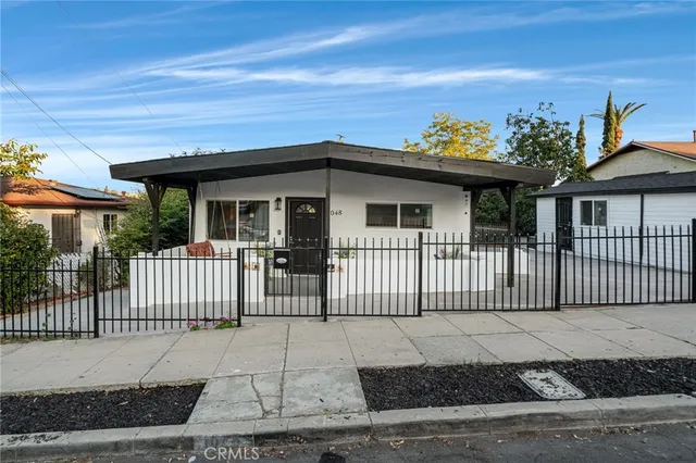 a view of a white house with wooden fence