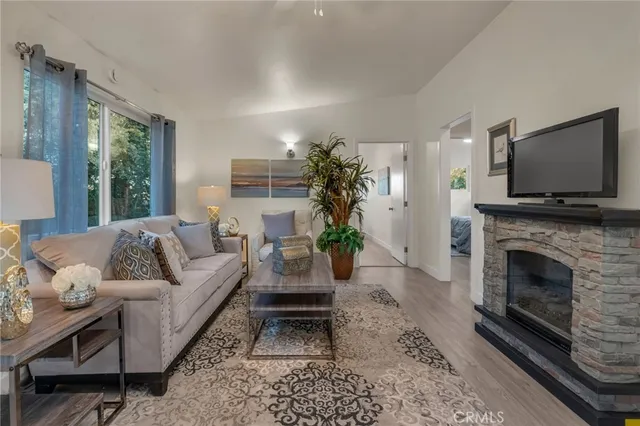 a living room with furniture a flat screen tv and a fireplace