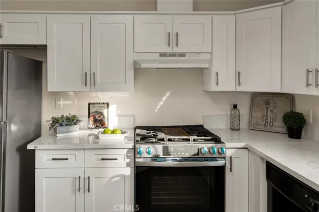 a kitchen with stainless steel appliances granite countertop a sink a stove and cabinets