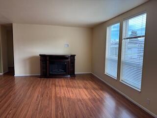 355 Colver Road, Unit 24 Talent, OR 97540 - Photo 4 of 21 an empty room with wooden floor fireplace and windows