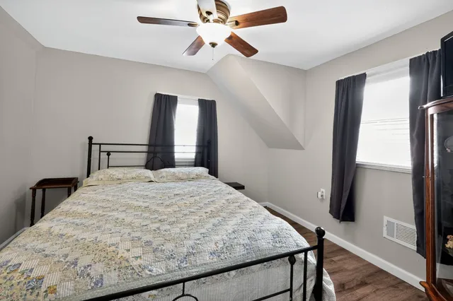 a view of a livingroom with a flat screen tv wooden floor and a ceiling fan
