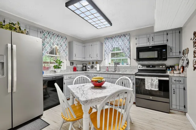 a kitchen with stainless steel appliances a stove a sink a microwave a refrigerator and cabinets