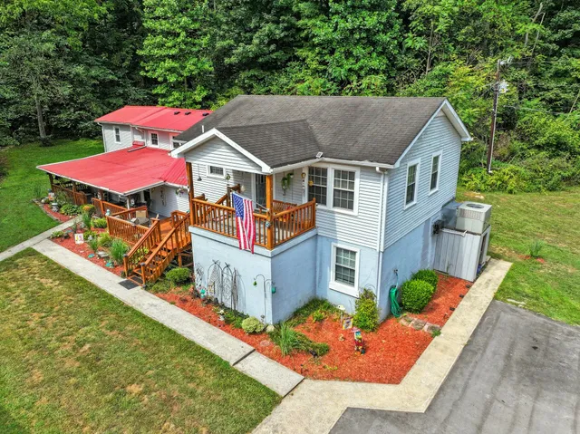 an aerial view of a house with a yard and a car park