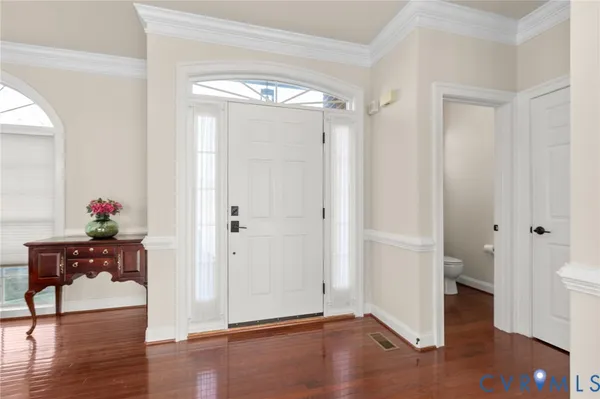 a kitchen with stainless steel appliances granite countertop a refrigerator a sink and white cabinets