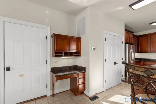 a kitchen with stainless steel appliances granite countertop a stove top oven a sink a dining table and chairs with wooden floor