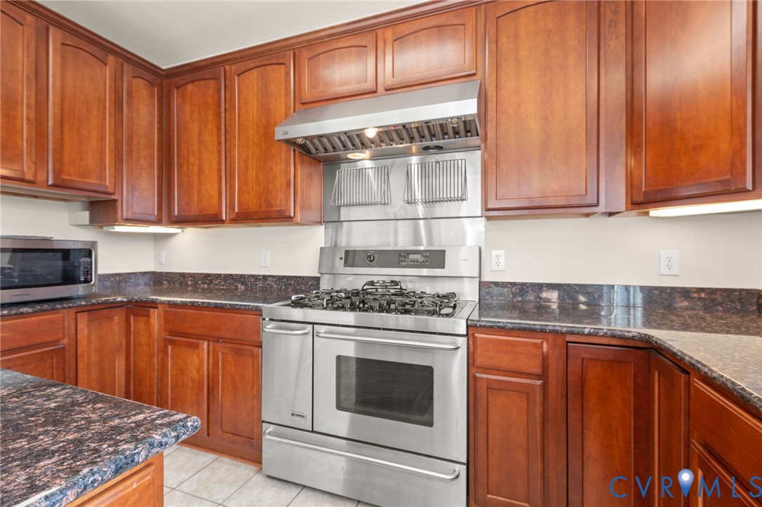 175 Shellfield Lane Colonial Beach, VA 22443 - Photo 30 of 100 a kitchen with granite countertop wooden cabinets and white appliances