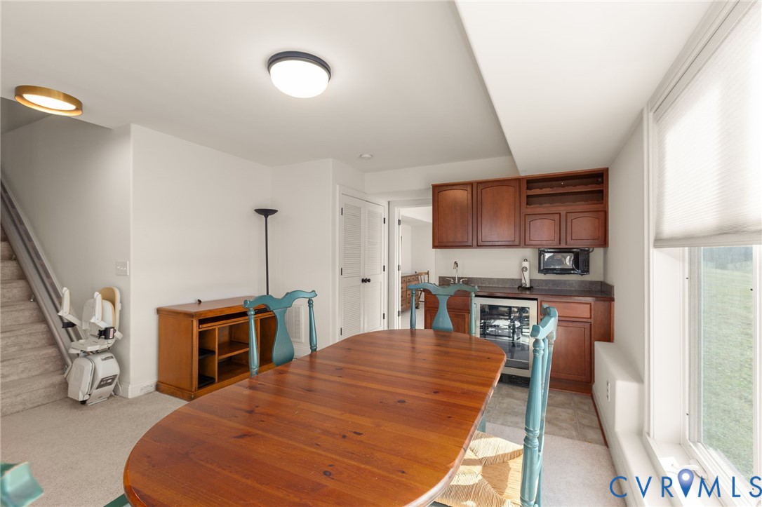 175 Shellfield Lane Colonial Beach, VA 22443 - Photo 59 of 100 a kitchen with stainless steel appliances granite countertop a stove top oven a sink a dining table and chairs with wooden floor