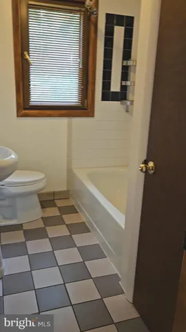 a bathroom with a granite countertop shower and a toilet