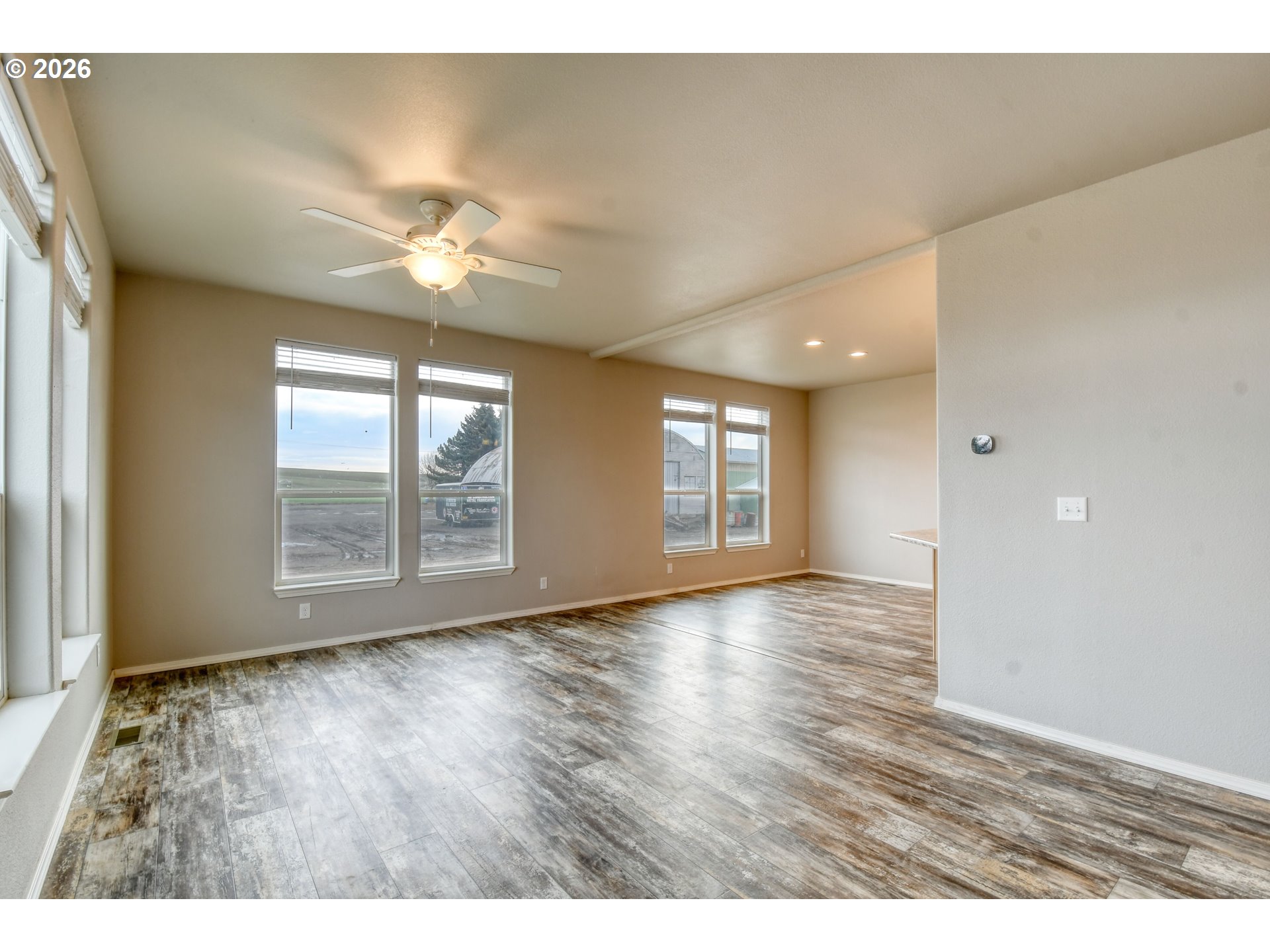 105 Columbia Street Helix, OR 97835 - Photo 5 of 34 a view of an empty room with a window and wooden floor