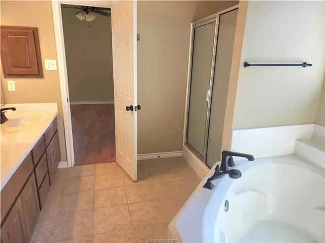 a bathroom with a tub sink and mirror