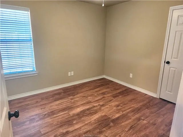 a view of a room with wooden floor and a window